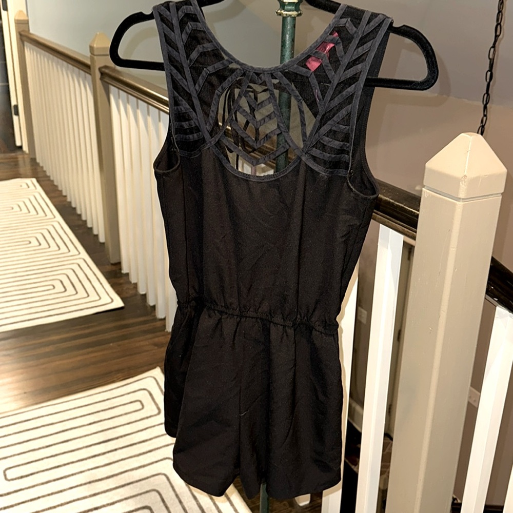 Beautiful black romper with lace front and open back. Has pockets!